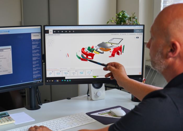 Kfz-Sachverständiger bewertet Unfallschaden am Computer.