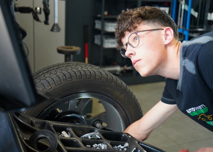 Mitarbeiter führt in der Kfz-Werkstatt einen Reifenservice durch.