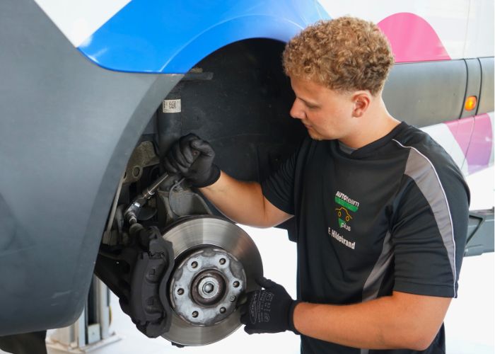 Werkstatt Mitarbeiter repariert Bremse an einem Fahrzeug in Kfz-Werkstatt in Augustdorf.